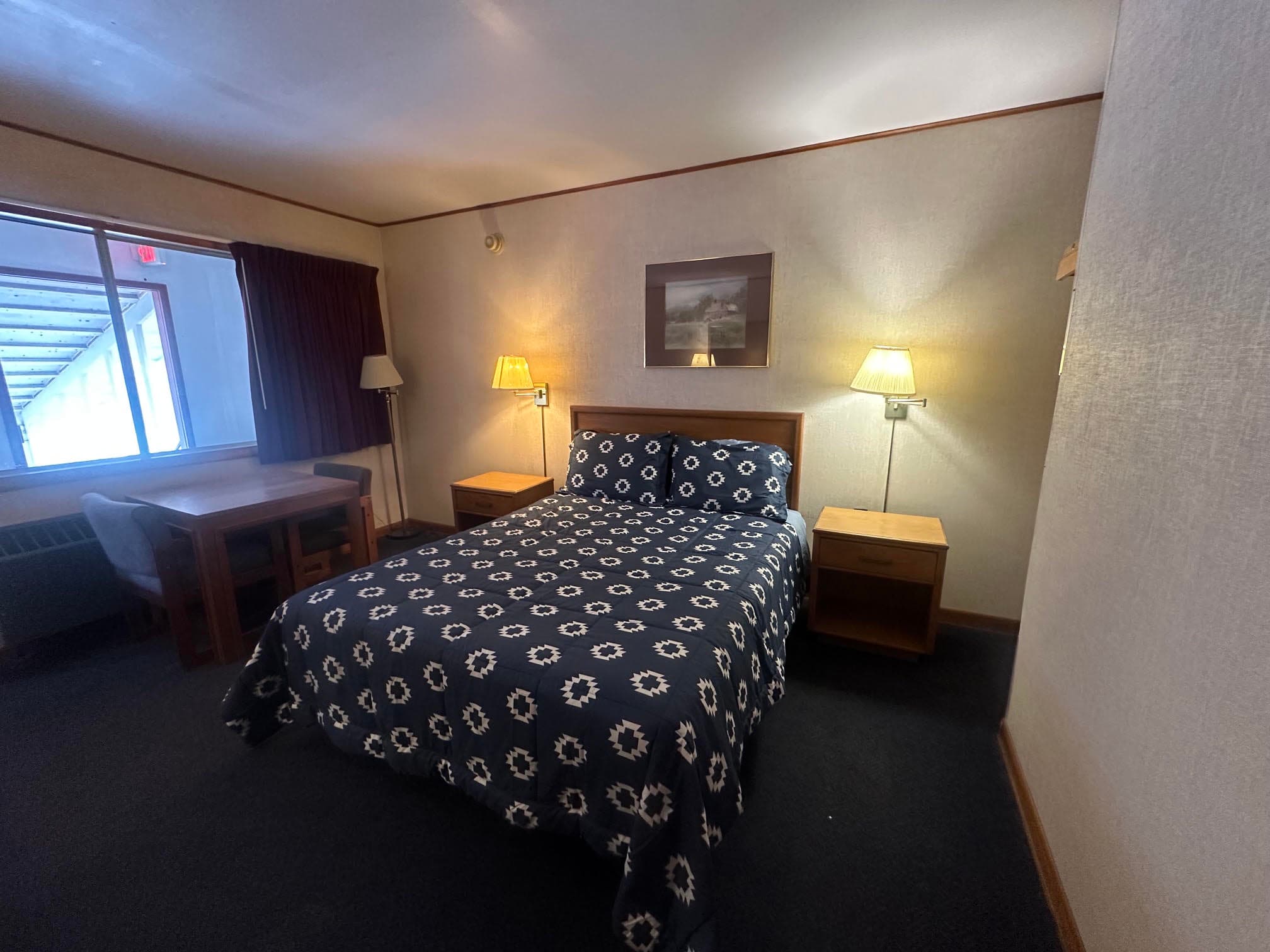 Guest room at Alpine Lodge with a bed and work table